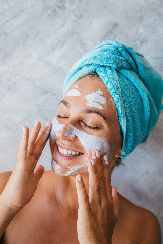 A Smiling Woman Applying Facial Cream